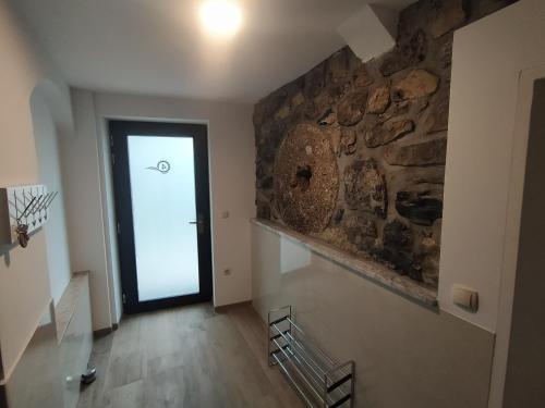 um corredor com uma parede de pedra e uma porta em Apartmaji Maln em Dolenjske Toplice