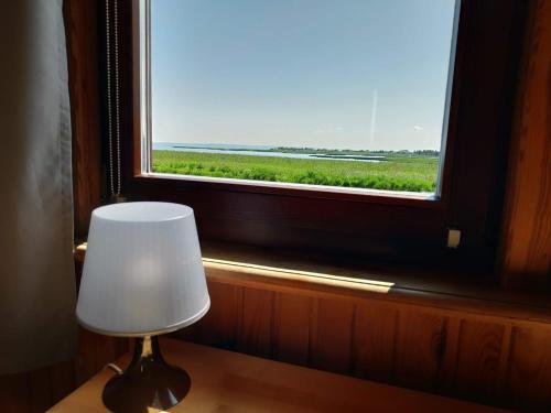 a white chair sitting in front of a window at Zalewowo domki letniskowe in Kąty Rybackie