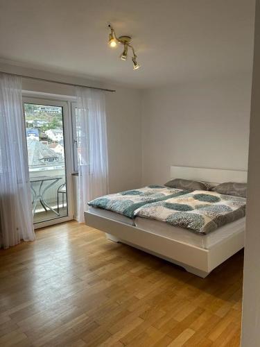 a bedroom with a bed and a door to a balcony at Paradiesisch Wohnen Bad Schwalbach in Bad Schwalbach