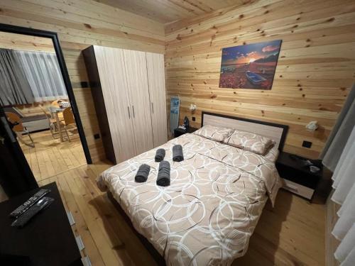1 dormitorio con 1 cama con pared de madera en Еко Къщи Къмпинг Созопол Еко en Sozopol