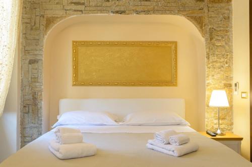 a bedroom with a white bed with towels on it at B&B Le Stanze di Ludovica in Termoli