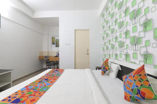 um quarto com uma grande cama branca com almofadas coloridas em The Ashiyana Inn Hotel em Patna