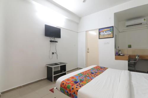 Habitación de hotel con cama y TV en The Ashiyana Inn Hotel, en Patna