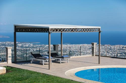 a gazebo with two chairs and a pool at Villa Golden Hill in Chania Town