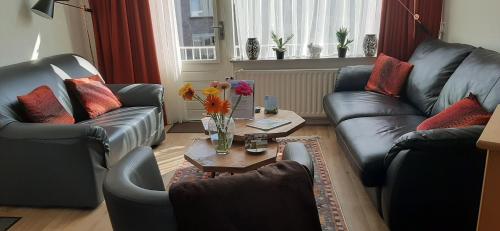 a living room with two couches and a coffee table at Logies Plevierstraat in De Koog