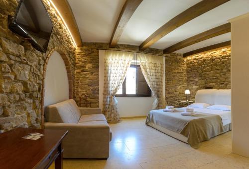 B&B Le Stanze di Ludovica في تيرمولي: غرفة نوم بسرير وجدار حجري