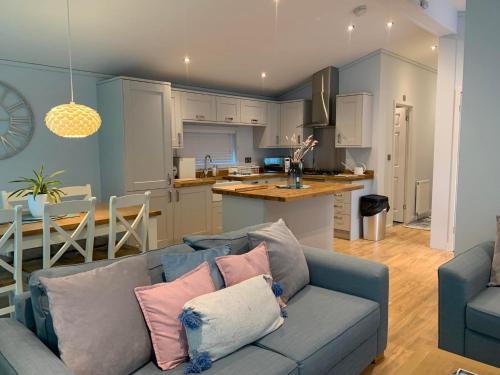 un soggiorno con divano blu e una cucina di Luxury Lodge Hoburne Devon Bay WG21 a Paignton
