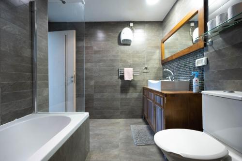 een badkamer met een bad, een toilet en een wastafel bij spacious apartment in Tel Aviv
