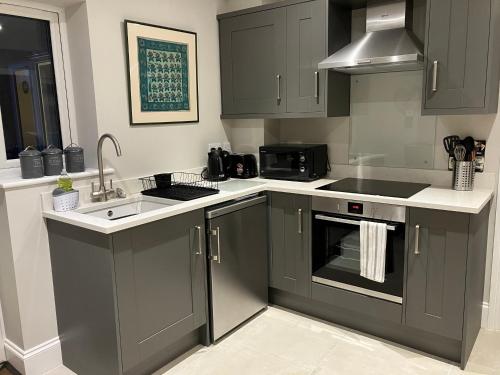 a kitchen with gray cabinets and a sink at HomeForYou - Holiday Home in the Wolds in Spilsby