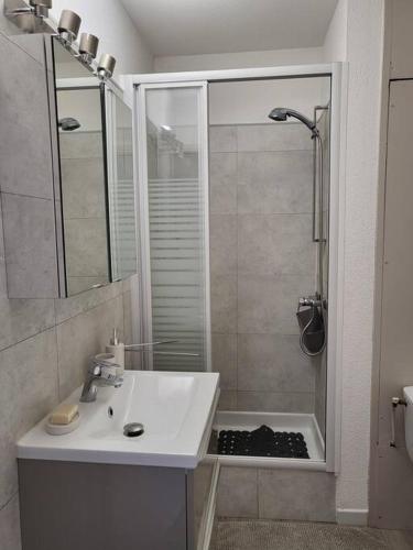 une salle de bain blanche avec un lavabo et une douche dans l'établissement Carnon Ouest Studio cabine 2 min à pied plage, à Mauguio