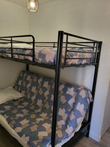 quelques lits superposés dans une chambre dans l'établissement Carnon Ouest Studio cabine 2 min à pied plage, à Mauguio