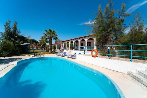 a swimming pool in front of a house at Villas Mina in Gennadi