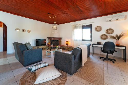 a living room with two chairs and a fireplace at Villas Mina in Gennadi