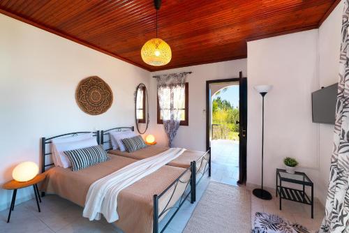 a bedroom with two beds and a patio at Villas Mina in Gennadi
