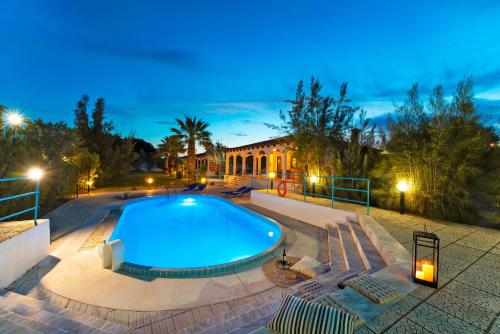 a swimming pool in front of a house at night at Villas Mina in Gennadi