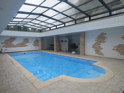 une grande piscine avec un plafond en verre dans l'établissement LA CHINOISERIE, à Binson-et-Orquigny