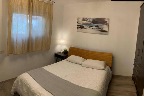 1 dormitorio con cama y ventana en Limor-resident, en Katzrin