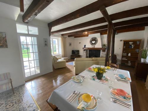 een woonkamer met een tafel met een witte tafeldoek bij « La Belle Vie » Brittany, ideal for 2 to 6 people 