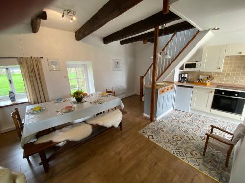 een woonkamer met een tafel en een keuken bij « La Belle Vie » Brittany, ideal for 2 to 6 people 