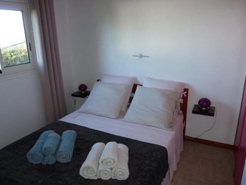 a bedroom with a bed with towels on it at petite maison traditionnelle in Saint-Leu