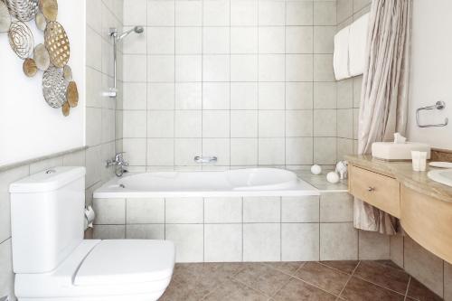 baño blanco con bañera y aseo en Frank Porter - Canal Residence, en Dubái