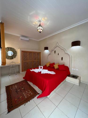 a bedroom with a large red bed with a red blanket at Riad excellence luxe in Marrakech