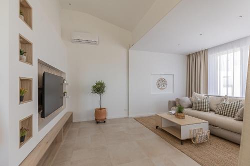 a white living room with a couch and a tv at Premium Residence Virotel in Vir