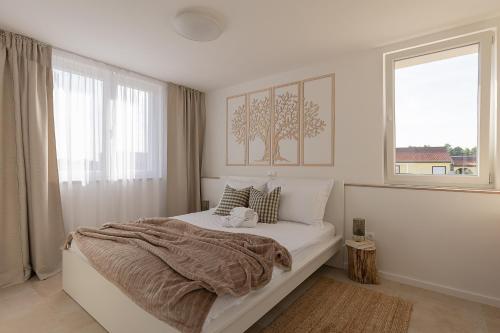 a bedroom with a bed with a blanket and a window at Premium Residence Virotel in Vir