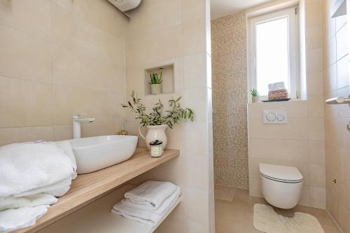 a bathroom with a white sink and a toilet at Premium Residence Virotel in Vir
