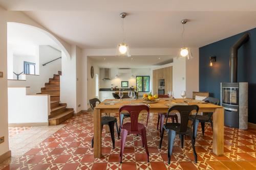 Il dispose d'une cuisine et d'un salon avec une table et des chaises en bois. dans l'établissement Sous les remparts la maison Pimprenelle, à Carcassonne