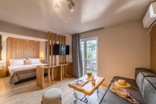 um quarto de hotel com uma cama e um sofá em Skiathos Thalassa Cape, Philian Hotels and Resorts em Megali Ammos