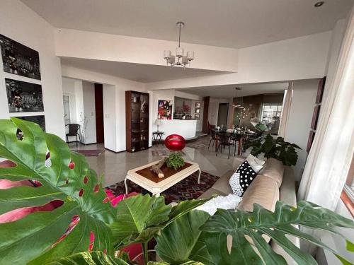 uma sala de estar com um sofá e uma mesa em Amplio, cómodo y moderno apartamento cerca al Mall em Lima