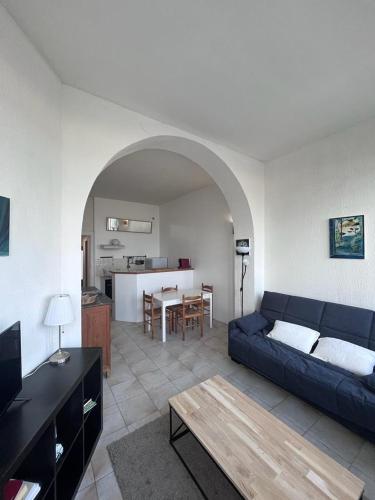 un salon avec un canapé bleu et une table dans l'établissement Maison sur mer Palavas, à Palavas-les-Flots