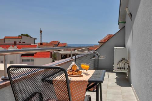 einen Balkon mit einem Tisch und 2 Gläsern Orangensaft in der Unterkunft Villa Juric in Baška Voda