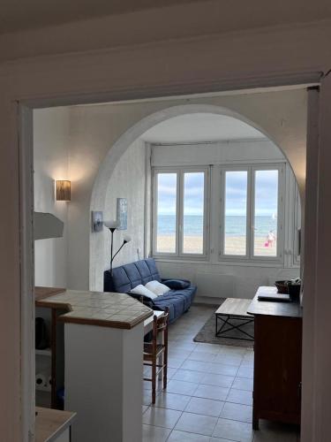 un salon avec un canapé bleu et une table dans l'établissement Maison sur mer Palavas, à Palavas-les-Flots