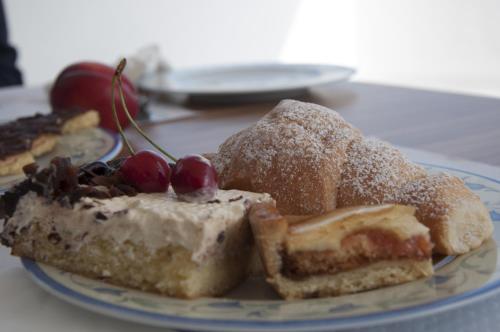 a plate of food on a table with desserts at Alma di Alghero Hotel in Alghero