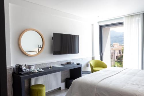 um quarto com uma cama, um espelho e uma televisão em 11Suites em Aigio