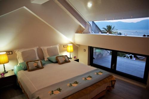 a bedroom with a large bed with a large window at Seacret Apartments in Selianitika