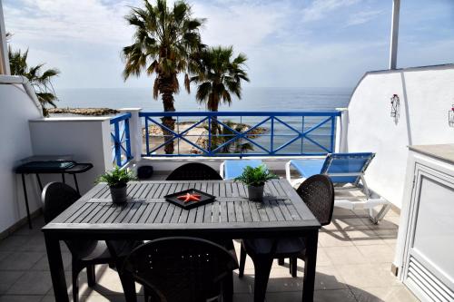 una mesa en un balcón con vistas al océano en Apartamentos La Perla Azul, en Málaga