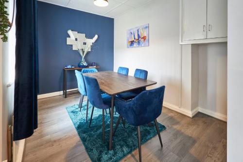 uma sala de jantar com uma mesa de madeira e cadeiras azuis em Host & Stay - King Edward's em Amble