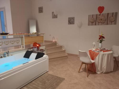 a room with a bath tub and a table and stairs at B&B Tre Sorelle in Surbo