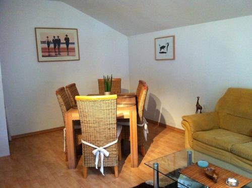 een woonkamer met een tafel en stoelen en een bank bij Gemütliche 75 qm Wohnung mit Balkon und Blick auf das Goldeck in Spittal an der Drau