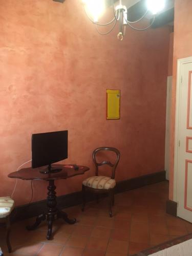 a room with a table and a tv on a wall at Au temps d'Autrefois in Nolay
