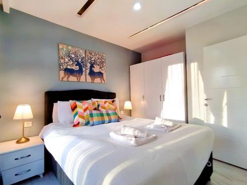 1 dormitorio con 1 cama grande y 2 toallas. en Central and Fully Furnished Flat in Muratpasa, en Antalya