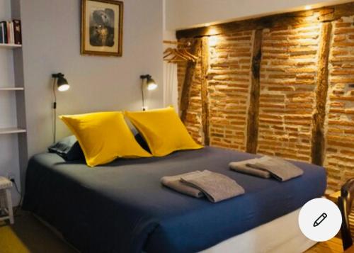 Schlafzimmer mit einem Bett mit gelber und blauer Bettwäsche in der Unterkunft Maison centre historique Le Préau saint Jacques in Castres