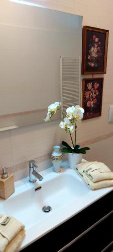 a bathroom sink with a vase of flowers on it at VALERIA'S HOUSE in Terlizzi