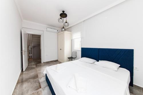 a bedroom with a white bed and a blue headboard at Sea in Gundogan