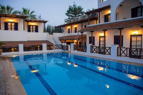 a hotel swimming pool in front of two buildings at 7 Islands in Spetses
