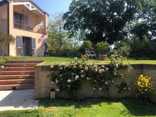 un muro di contenimento con fiori di fronte a una casa di B&B Villa FioreConero a Montacuto
