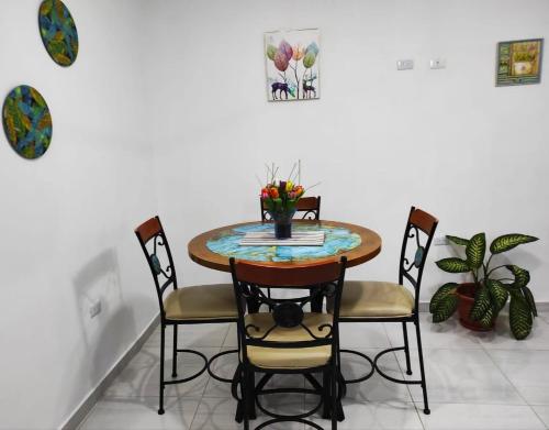 a table with chairs and a vase of flowers on it at 100 Mts From Malecon Weeklymonthly Discount in Santa Bárbara de Samaná